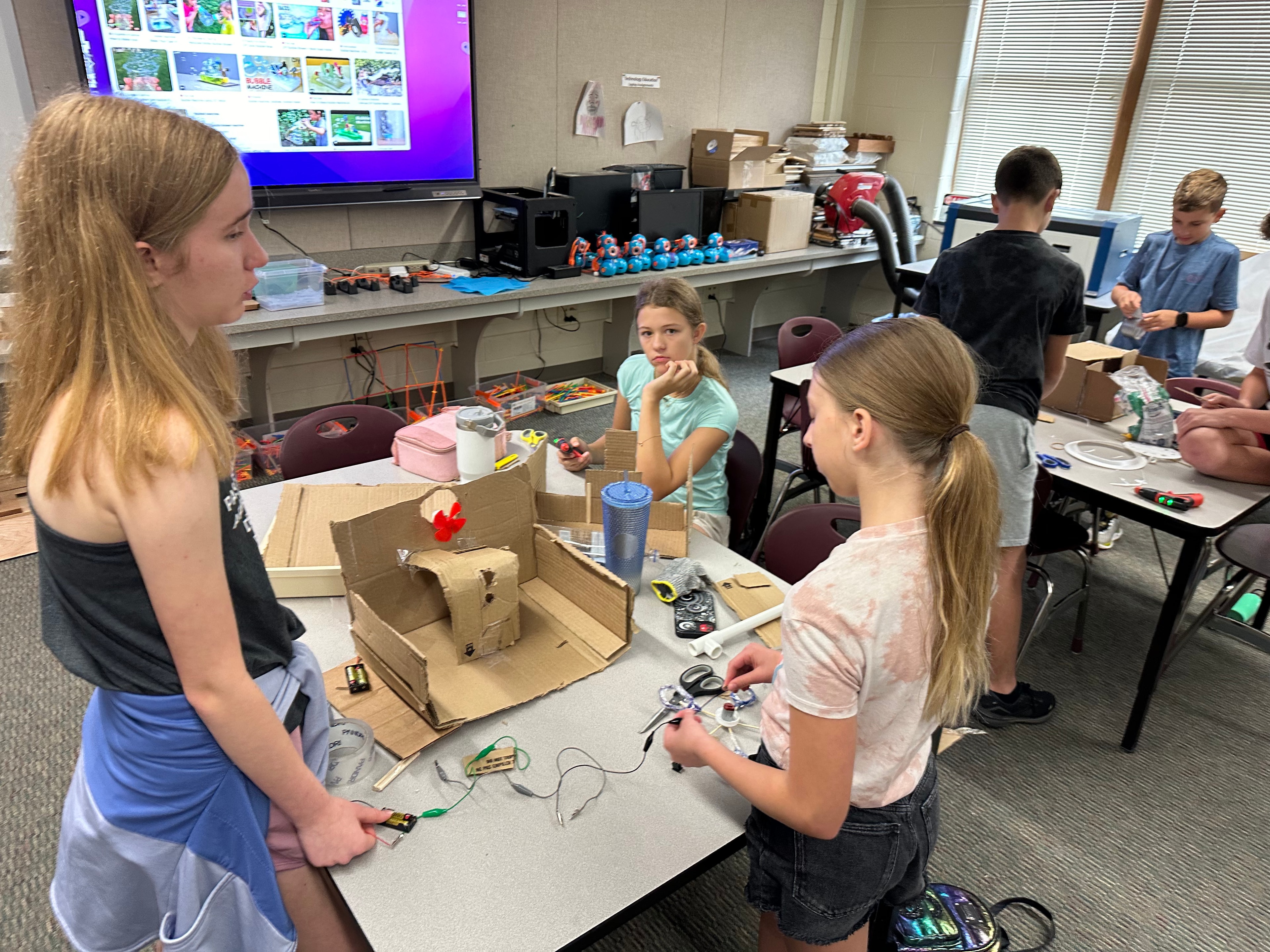 Students learning with an instructor and hydraulic arm