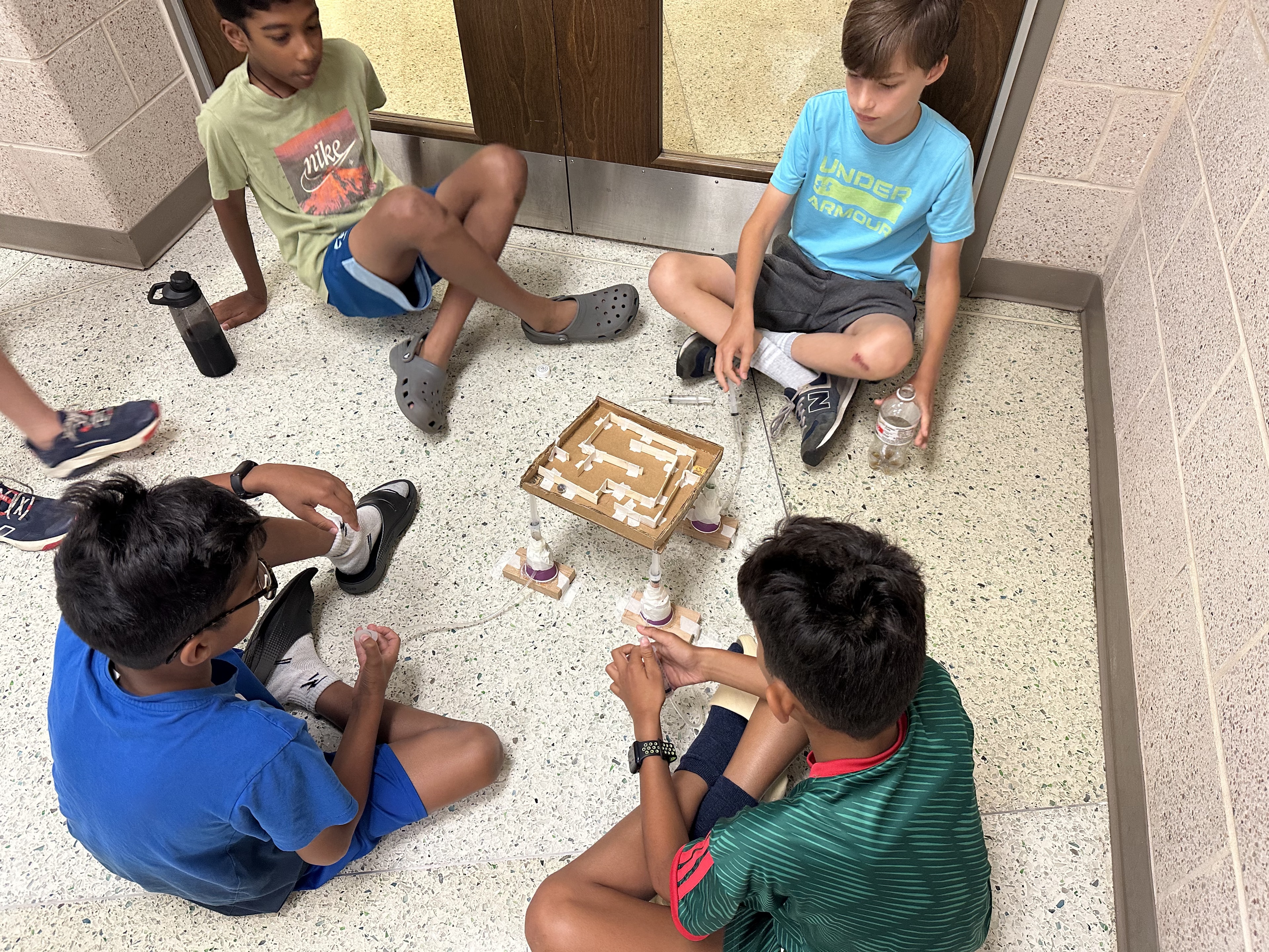 Students testing a hands-on hydraulic maze project